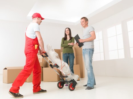 Removal workers carrying items down stairs in a flat